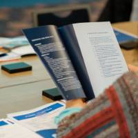 A woman looking through an Alumni Champions brochure.